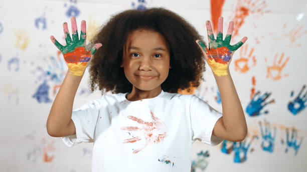 istock African student put hands up together show colorful stained hands. Erudition. 1913392878