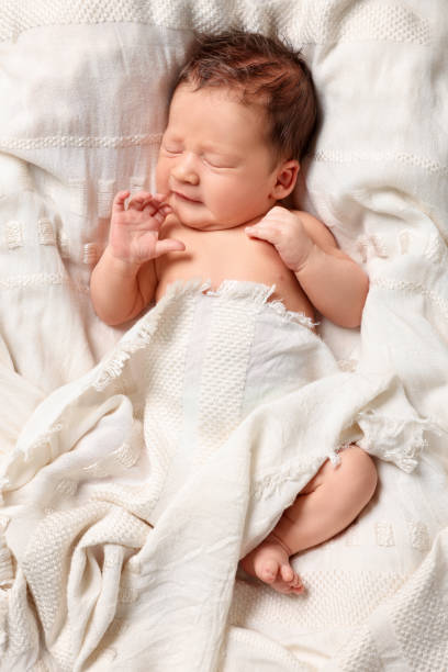 istock Cute newborn baby sleeping on white blanket, top view 1913395971