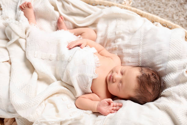 istock Cute newborn baby sleeping on white blanket in crib 1913395972