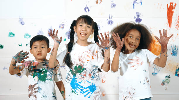 istock Diverse students put hands up together show colorful stained hands. Erudition. 1913415479