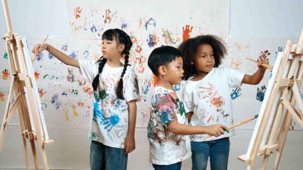 Diverse student painted or draw canvas at stained wall in art lesson. Erudition.