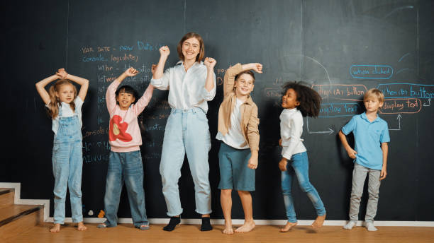 istock Multicultural student and teacher smiling and standing at blackboard. Erudition. 1913441861
