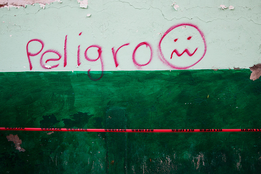 Graffiti  and a sad emoji on a wall that says