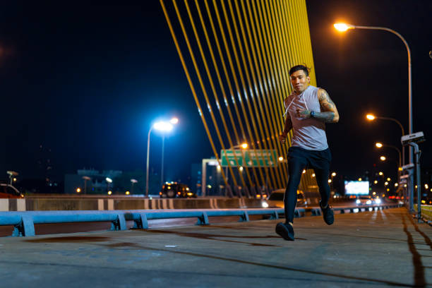 istock Asian man exercising in the city at night. 1913683565