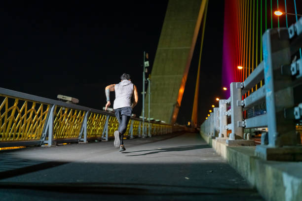istock Asian man exercising in the city at night. 1913684085