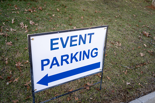 A white sign with blue lettering that reads, Event Parking.