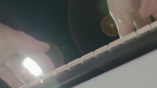 A man plays on a synthesizer keyboard (piano) bottom view