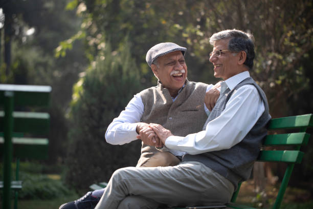 istock Happy elderly friends resting on park bench 1913829376