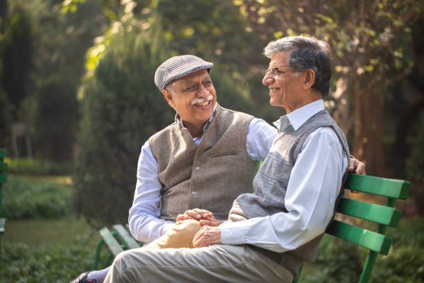 istock Happy elderly friends resting on park bench 1913829902