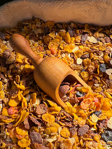 Stock photo showing close-up, elevated view of large sack filled with muesli breakfast cereal being sold by a market trader from outdoor stall display.