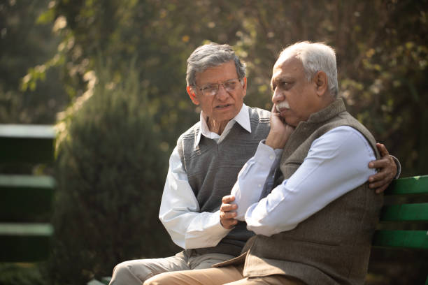 istock Man consoling stressed friend in park 1913853838