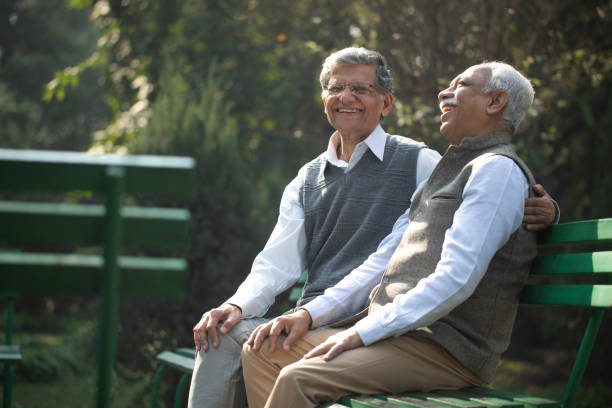 Happy elderly friends resting on park bench