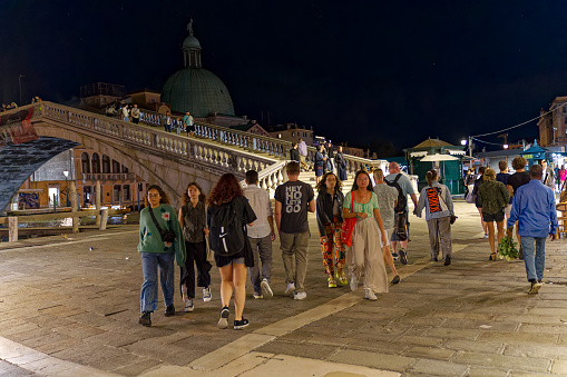 Tourists at bridge named Ponte degli Scalzi at the old town of Venice on a dark summer night. Photo taken August 6th, 2023, Venice, Italy.