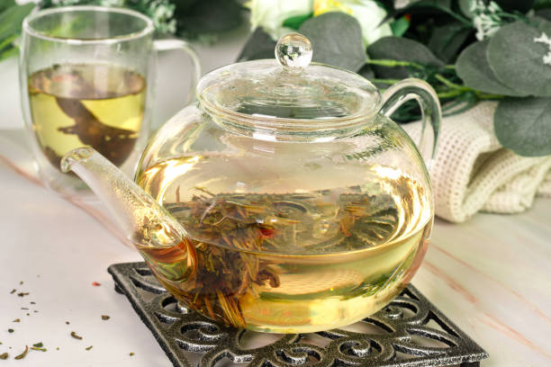 istock Teapot and glass cup with blooming tea flower 1913963374