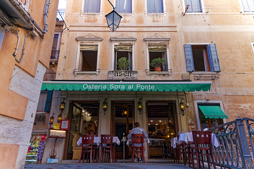 Lyon France: A sidewalk restaurant/brasserie/bouchon with traditional red chairs and awning in sunny Vieux Lyon.