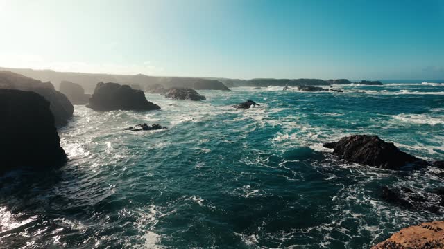 Slow motion shot of the Pacific ocean waves crashing on rock formations on the coast of Fort Bragg