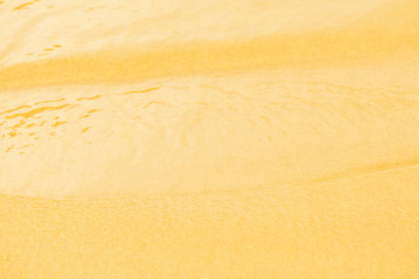 istock Yellow water with ripples on the surface. Defocus blurred transparent gold colored clear calm water surface texture with splashes and bubbles. Water waves with shining pattern texture background. 1913972108