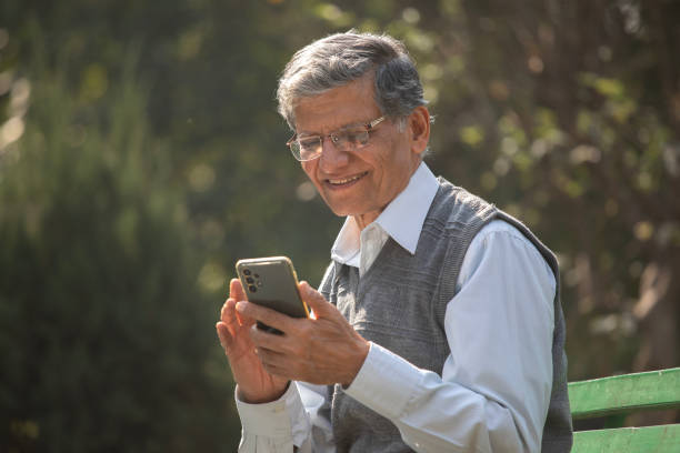 istock Old man texting mobile phone in park 1913982895