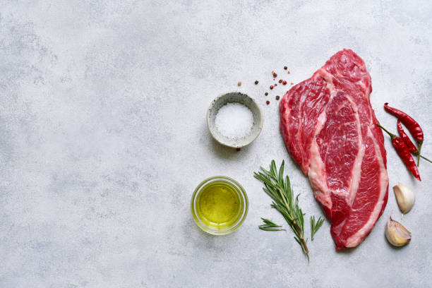 istock Raw organic marbled beef steak with ingredients for cooking. Top view with copy space. 1913986523