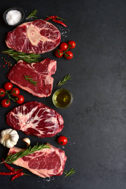 different types of raw marbled beef steaks : t-bone, ossobuko, spider and rib eye with ingredients for cooking. top view with copy space. - veal t bone steak raw steak zdjęcia i obrazy z banku zdjęć