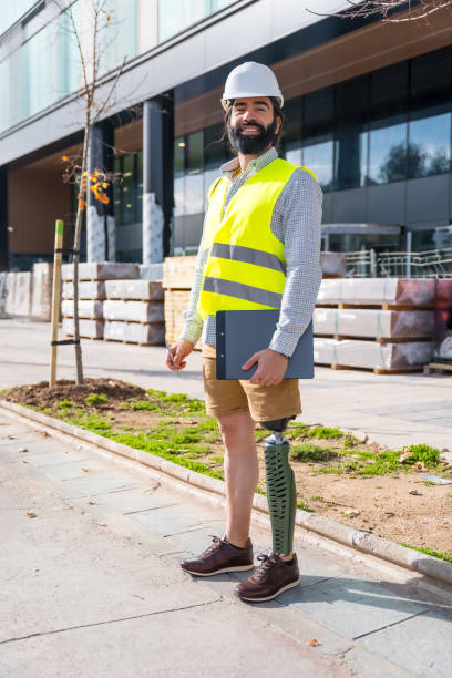 istock Employee with prosthetic leg on construction site wearing protective equipment 1914056263