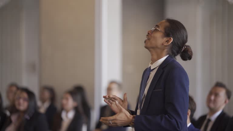 Asian Young Malay entrepreneur asking question at business conference standing among participants