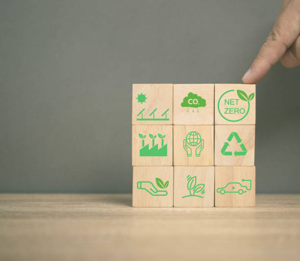 istock net zero emissions and Carbon neutrality concept. sustainable and clean tech. global warming. Environmental protection, climate eco energy. Man point on the net zero icon cube wood. Renewable power. 1914120047