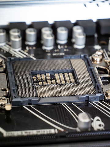 Closeup view of a CPU socket on a black motherboard, semiconductor electronic industry, printed circuit board, computer science