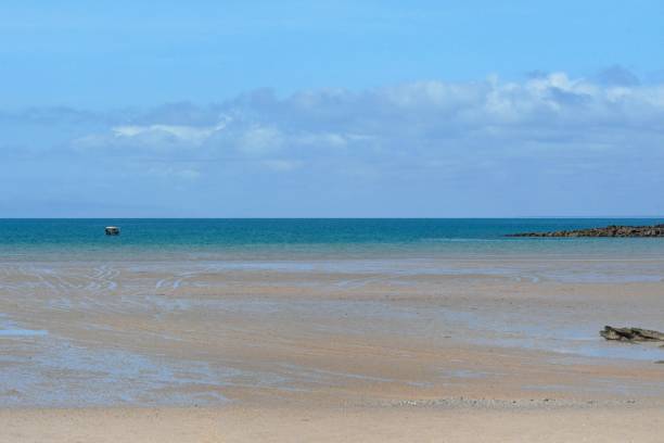 istock A small boat on turquoise water near a sandy beach. 1914149413