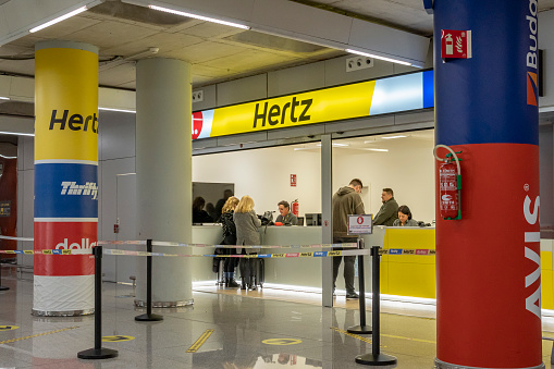 Palma de Mallorca, Spain; january 03 2024: General view of the arrivals terminal at Palma de Mallorca international Airport with tourists arriving. Car rental stand of the company Hertz