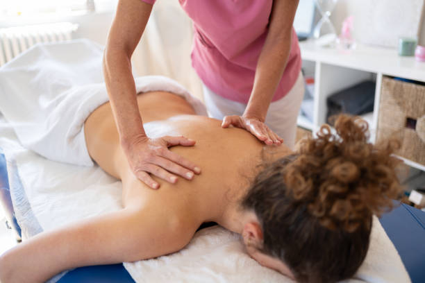 istock Professional massage therapist treating back of client 1914201643