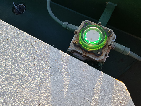 Green light on the top deck of a ship, closeup of photo