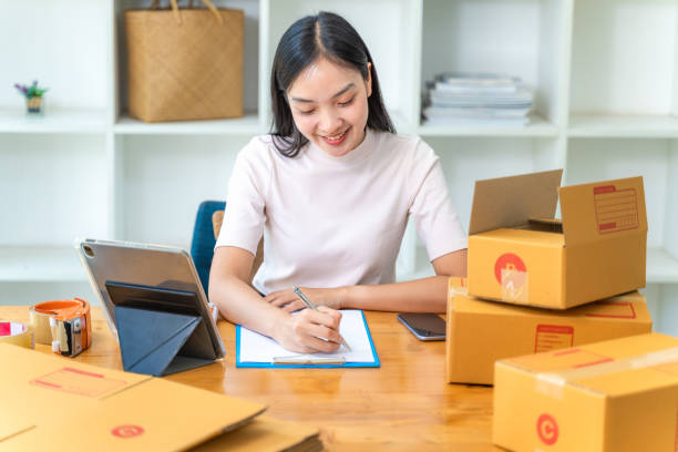 istock Happy young online businesswoman working at her home office writing down her plan on a notepad 1914216246