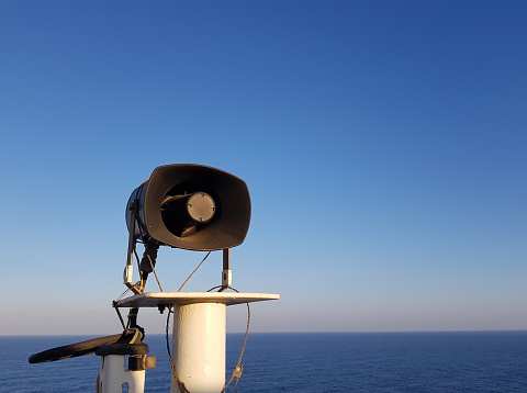 Loudspeaker on the mast of a ship against the blue sky