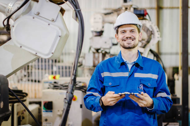 istock portrait happy smiling engineer service staff worker in robotic workshop robot arm plant assembly industry. 1914255774