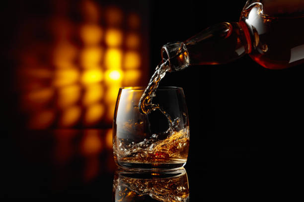 istock Pouring whiskey from a bottle into a glass. 1914319139
