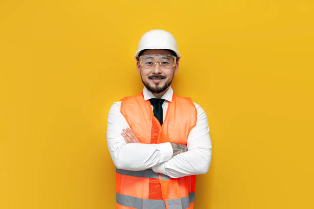 istock asian builder engineer in uniform on yellow isolated background, male korean man in hard hat and work vest 1914322771