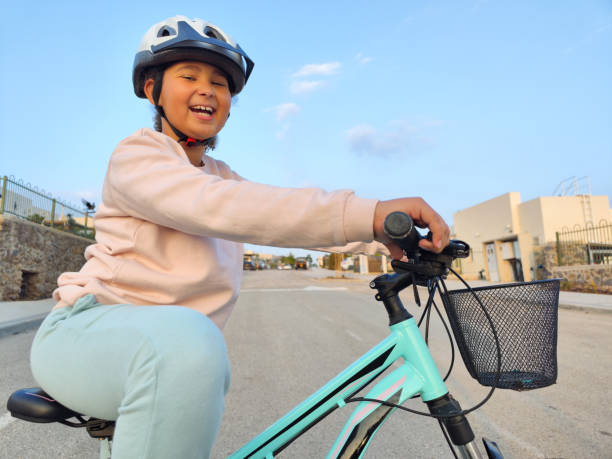 Close-up image of a Nine-year-old happy girl sitting on her new bicycle, posing.