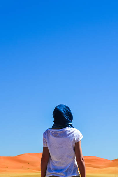 istock Young woman looking at the red sand dunes 1914426156