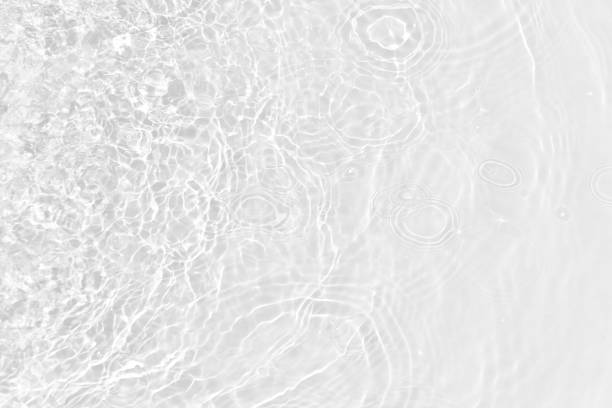 istock White water with ripples on the surface. Defocus blurred transparent white colored clear calm water surface texture with splashes and bubbles. Water waves with shining pattern texture background. 1914443955