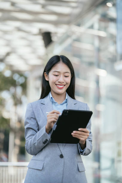 istock Business woman reading stats and graphs on paperwork with Tablet. 1914460286