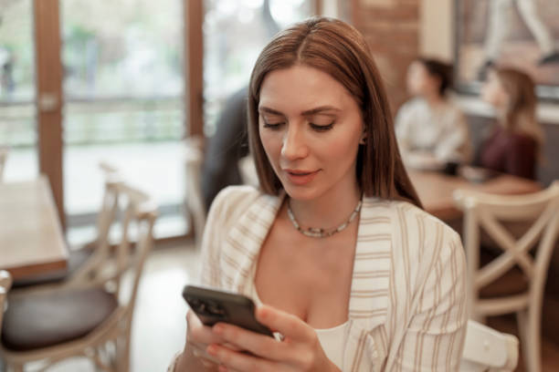 istock Woman Using Smartphone in Coffee Shop 1914460304