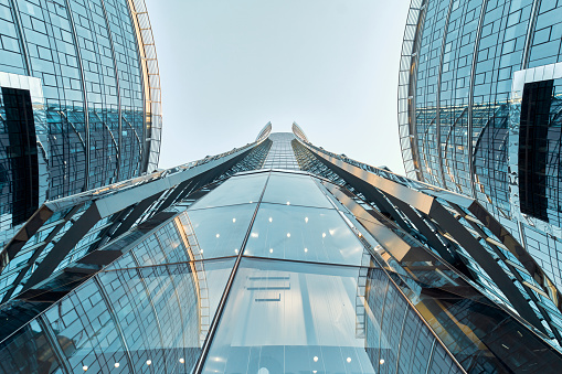 Modern glass skyscrapers against the sky. Bottom up view. Economics, finance, business concept. Modern buildings in the business district.