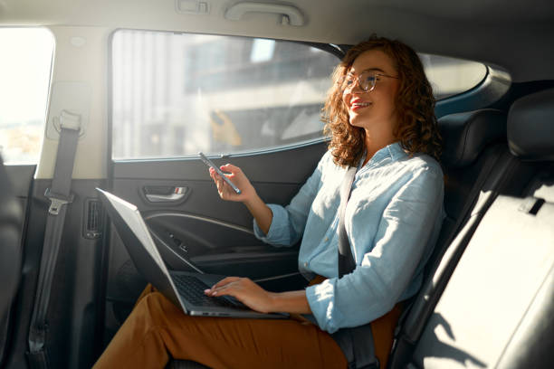 businesswoman sitting in car - taxi travel business women foto e immagini stock