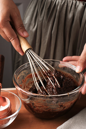 Mixing Melted Chocolate and Cocoa Powder in Large Bowl to Make Dough/Mixture/Batter for Delicious Homemade Brownie Cake on Wooden Table, Using Ballon Whisk