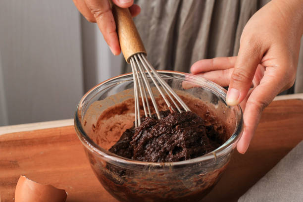 istock Woman Hand Mixed Chocolate Batter on Clear Bowl with Baloon Whisk Step by Step Baking Preparation in the Kitchen, Making Chocolate Cake or Brownies 1914475223