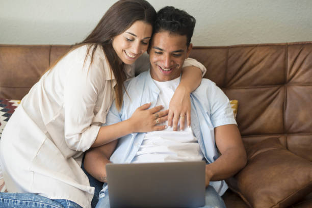 istock Young couple moving to a new home relaxing sitting on the sofa using computer laptop, smiling happy for moving to new apartment 1914501064