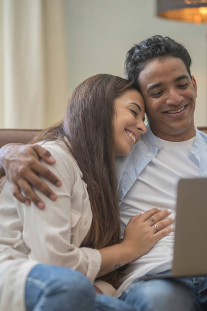 istock Young couple moving to a new home relaxing sitting on the sofa using computer laptop, smiling happy for moving to new apartment 1914505222