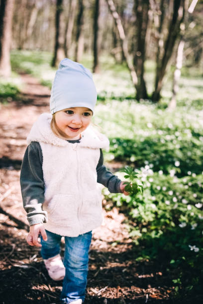 istock Small girl runs in the forest covered with anemones 1914518310