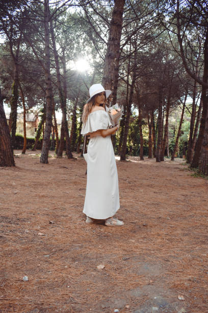 This portrait photos was tooken in small Town in Istanbul. Young woman holding a bouquet flower and wearing nude tons outfit.